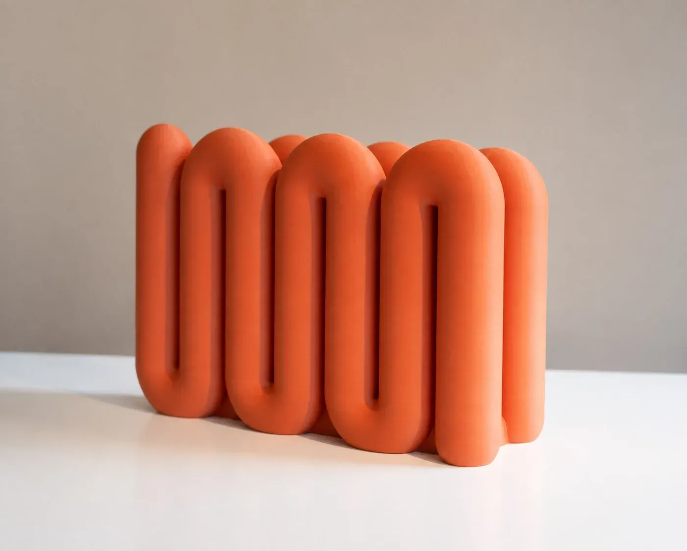 Soporte Onda naranja solo, sobre una mesa blanca