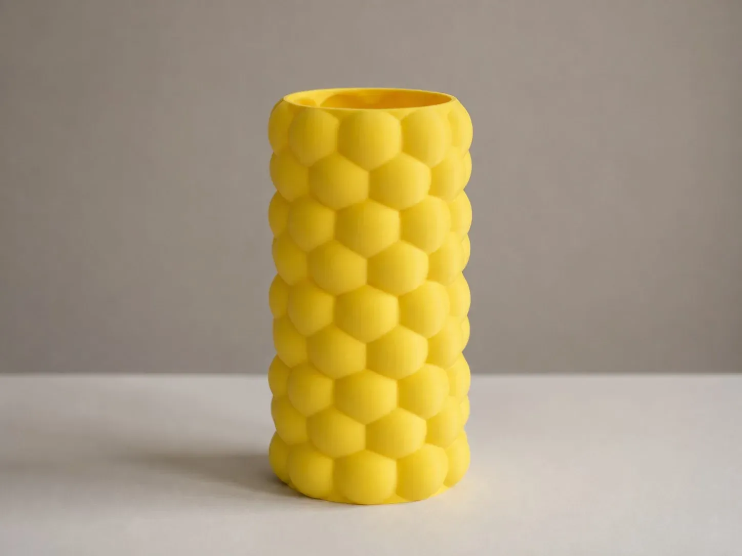 Florero Colmena amarillo de frente, con el relieve hexagonal a la vista