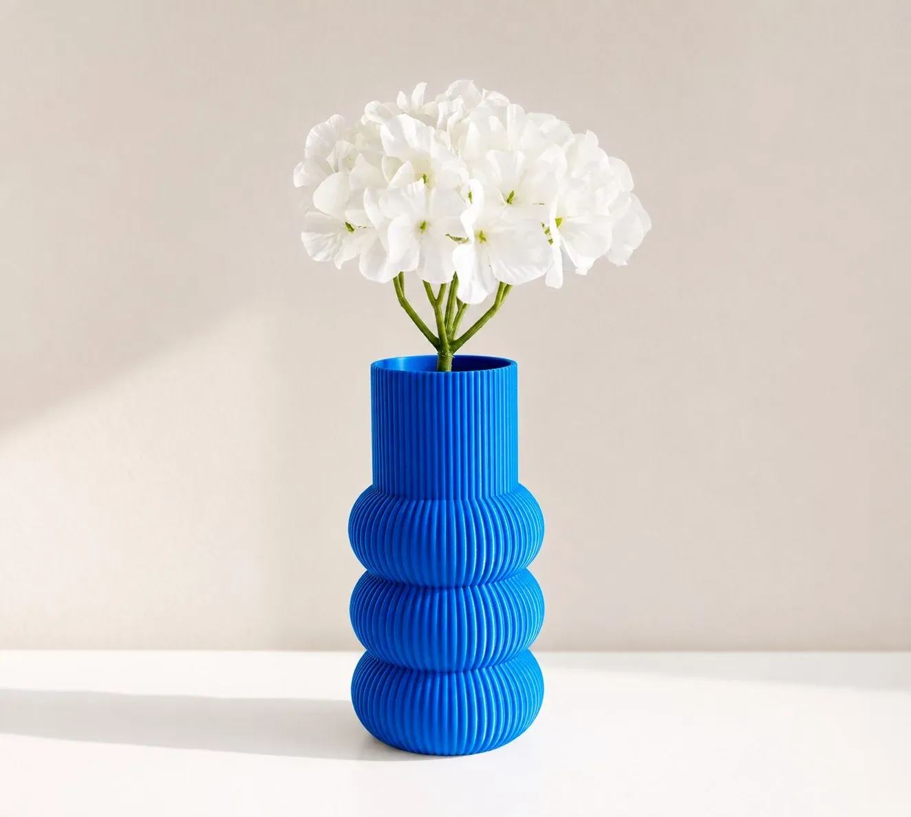 Florero Anillos azul con un ramo de flores blancas