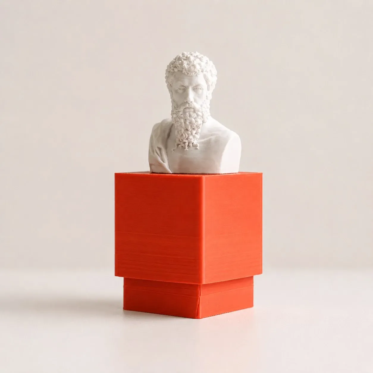 Busto clásico blanco sobre el pedestal cúbico naranja del clicker, de frente