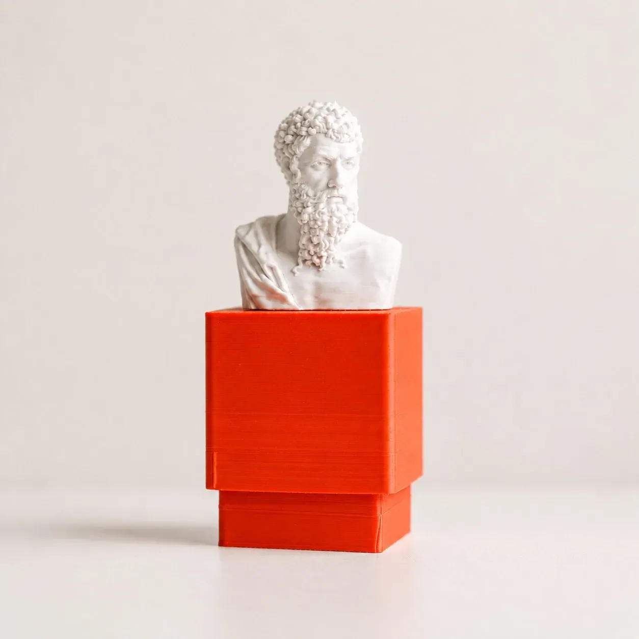 Clicker Aristóteles en vista de ángulo, con el busto sobre el pedestal naranja