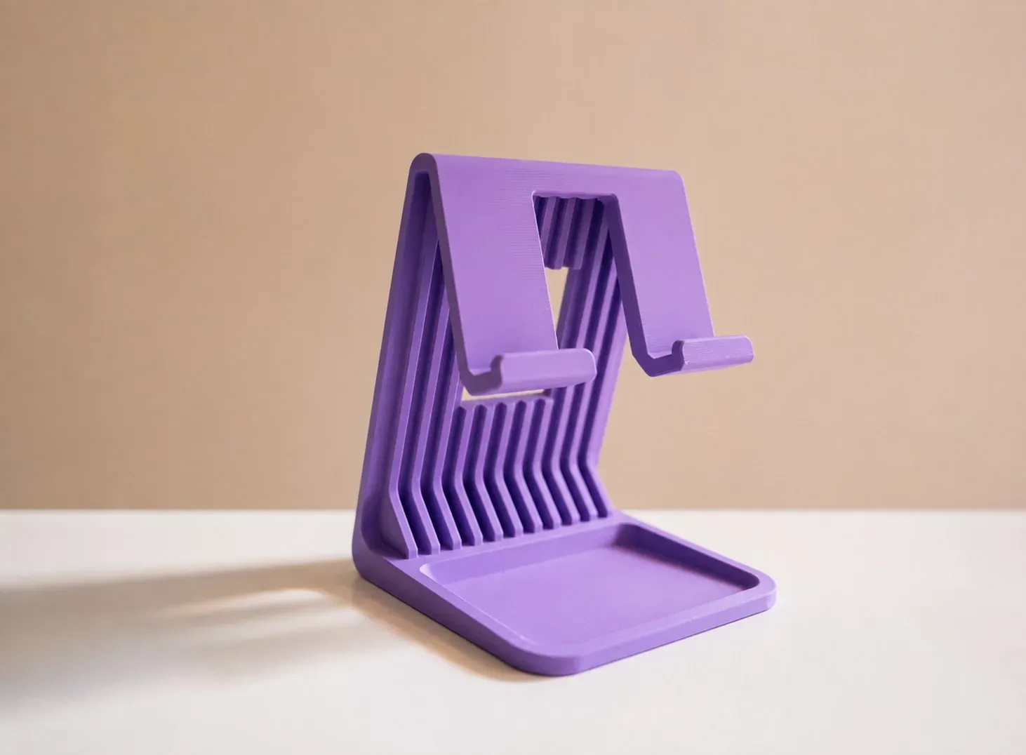 Soporte plegable lila visto en ángulo, con la bandeja de la base a la vista